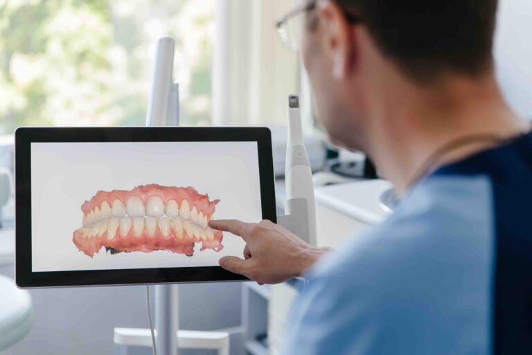 dentist looking at 3d imaging of teeth on screen